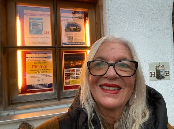 Brigitte Thoma vor dem Plakat im Wirtshaus Flößerei
